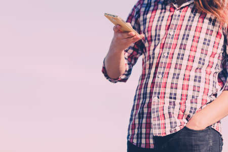 Man casual style outdoor holding cell phone in hand, guy using smartphone copy spaceの写真素材