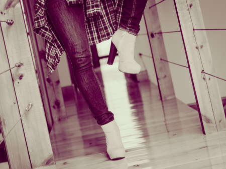Casual clothing everyday fashion glamour garment. Closeup woman legs wear jeans high heels and flannel shirt.の写真素材