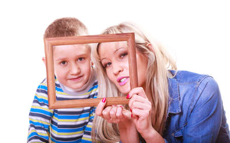 Spending time family bonds parenthood. Mother and son have fun play with empty picture frame hold in hand.の写真素材