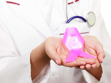 Healthcare, medicine and breast cancer awareness concept. Doctor showing pink ribbon aids symbolの写真素材
