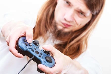 Addiction effects concept. Young unhappy depressed man with pad joystick playing games. Male...