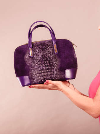 Love to shopping. Satisfaction from buying new fashionable accessories and clothes. Woman hands with purchase. Female in pink with black bag.の写真素材