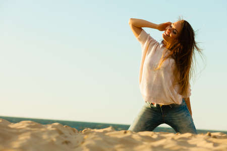 Joy and carefree. Gorgeous long haired woman having fun on beach. Young joyful attractive girl feels...