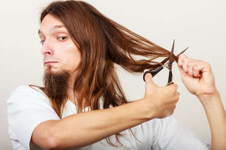 Trim and cut concept. Young handsome man cutting his hair. Change of look.  Barber and hairdresser.の写真素材