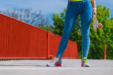 Summer sport and active lifestyle. Cool teenage girl skater riding skateboard on the street....