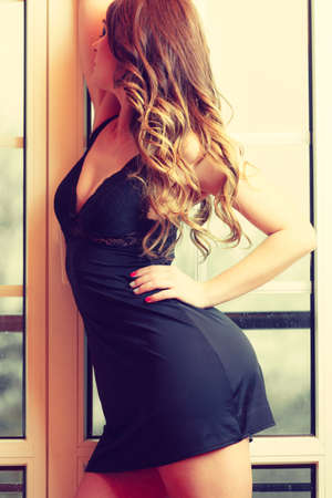 Sensuality and fashion. Young seductive sexy attractive woman in lingerie indoors french doors.