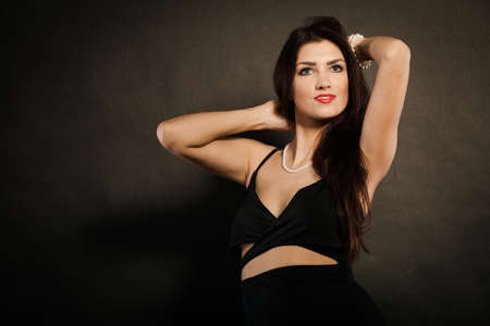 Party celebration concept.  Magnificent long hair woman red lipstick wearing black evening dress...