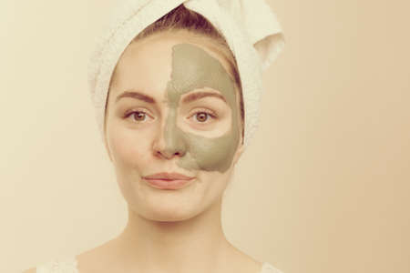 Skin care. Woman face with green clay mud mask. Girl taking care of oily complexion. Beauty...