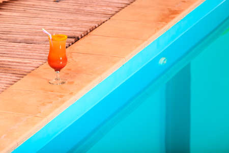 spa relaxation or travel concept. Swimming pool at hotel and  cocktail glass close upの写真素材