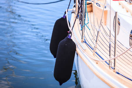 Yachting. Sailboat in the sea different parts of yacht. Side of hull with black fendersの写真素材