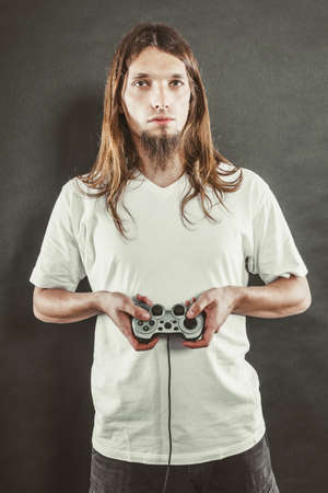 Addiction and dependency concept. Young man with pad joystick playing games. Male addicted to...