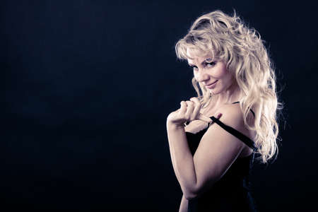 Sexiness of women. Attractive sensual blonde adult woman on dark background. Sexy beauty middle aged...