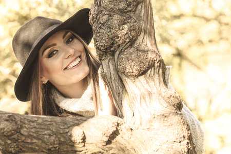 Young beauty woman wearing stylish autumnal clothes relaxing in park. Portrait of fashionable...
