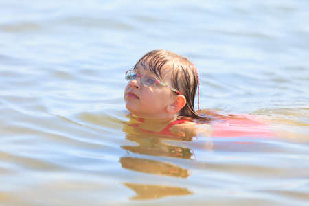 Little girl child swimming in ocean. Kid and woman bathing in sea water. Summer vacation holiday relax.の写真素材