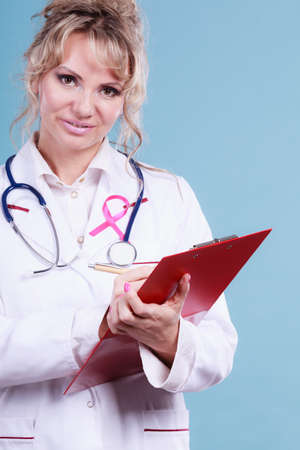 Diagnosis of breast cancer. Blonde middle aged female holding red folder with files of desease diagnose. Specialist inform patient about results.の写真素材