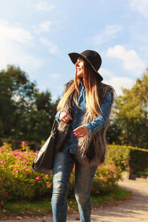 Autumnal fashion of women. Attractive young stylish model posing outdoors. Fashionable girl wearing trendy clothes walking in park.の写真素材