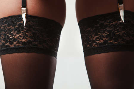 Sexuality and sensuality of women. Sexy gorgeous part body of woman in black lacy lingerie underwear. Seductive girl wearing stockings and garter belt.の写真素材