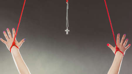 Tied hands. Human forced to pray. Fake faith belief concept. Christian religion. Praying to god because of society pressure.の写真素材