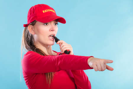Lifeguard woman girl supervising swimming pool water blowing whistle.