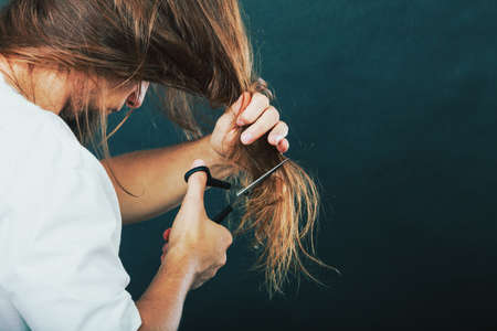Trim and cut concept. Young handsome man cutting his hair. Change of look.  Barber and hairdresser. Back view.の写真素材