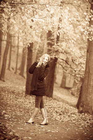 Autumn time concept, leisure. Girl is walking through the park. Young woman speanding free time outside, enjoying good autumnal weather.の写真素材
