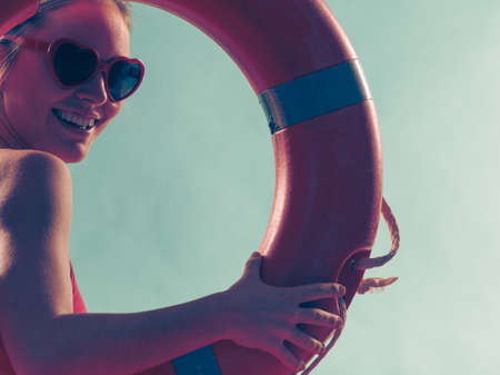 Happy glad young woman girl in heart shape sunglasses with ring buoy lifebuoy. Summer safety security.の写真素材