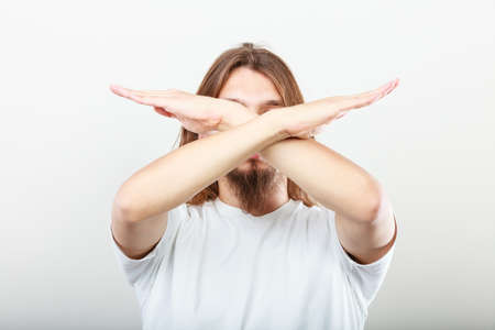 Forbidden. young long haired man making stop sign symbol. Hands gesture.