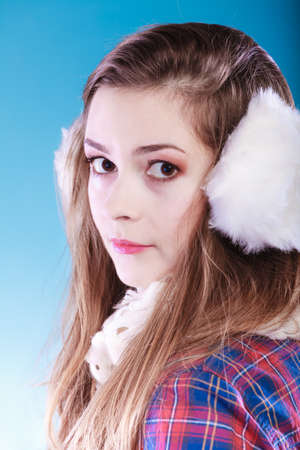 Teenage girl wearing fluffy white earmuff in winter fashion, cold time.の写真素材