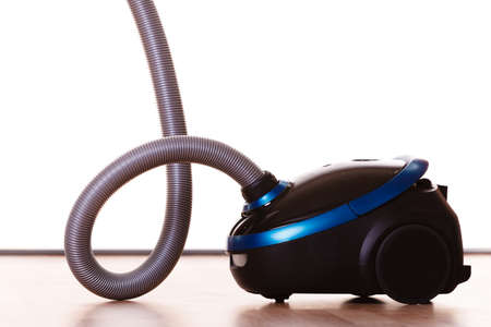 Vacuuming the house. Vacuum cleaner on wooden floor. Housework