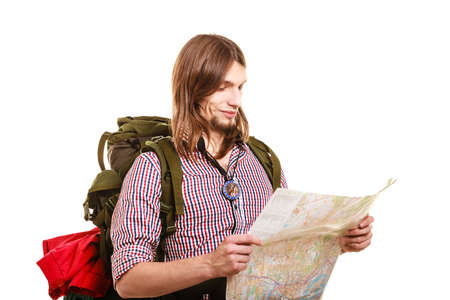 Man tourist backpacker reading map on trip. Young guy hiker searching looking for direction guide....