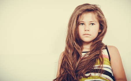 Portrait of sad unhappy little girl kid. Lonely depressed child. Bad mood.の写真素材