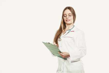 Woman medical doctor with stethoscope, clipboard and pen wearing white coat isolated. Professional...