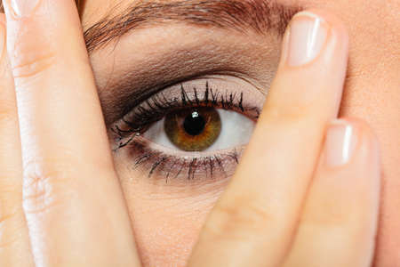 Face expressions emotion and distress. Female wear makeup cover her face with hand look through...