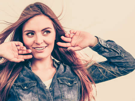 Young girl with waving hairs. Cheering woman standing in wind. Fashion coiffure leisure lifestyle concept.の写真素材