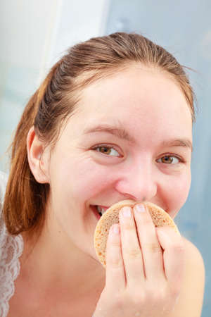 Morning hygiene. Woman cleaning washing her face with clean water in bathroomの写真素材