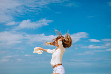 Happiness and craziness. Smiling crazy girl have fun outdoor. Young attractive woman with waving long hair playing on summer beach.の写真素材