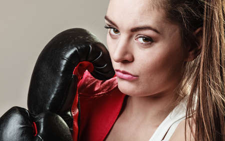 Training, boxing and exercises. Women lifestyle concept. Fit girl with gloves on grey background in studio.の写真素材