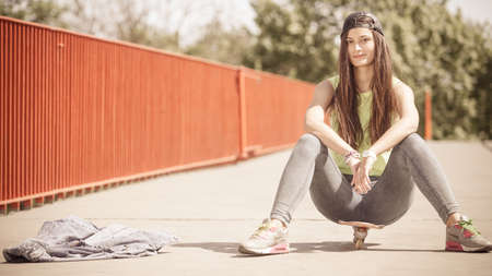 Summer sport and active lifestyle. Cool teenage girl skater riding skateboard on the street....
