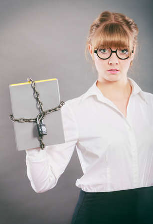 Businesswoman holding document file chained with padlock. Confidential secret data.の写真素材