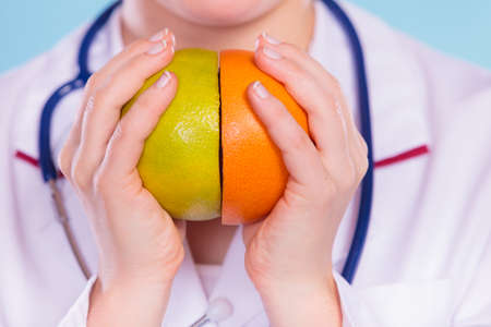Person human holding grapefruits in hands promoting healthy food fruit. Right eating nutrition and slimming concept.の写真素材
