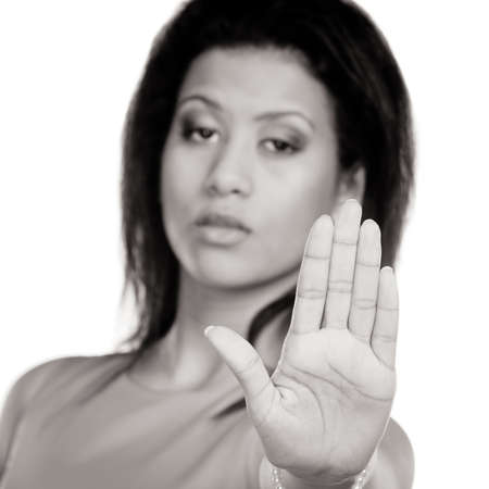 Portrait of pretty mixed race woman girl giving stop sign gesture isolated on white. Black and white photo.の写真素材