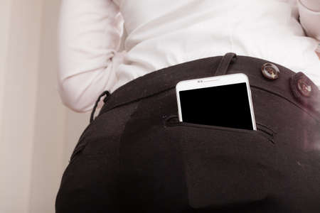 Technology and modern portable new generation. Smartphone in trousers pocket mobile phone business outfit.の写真素材