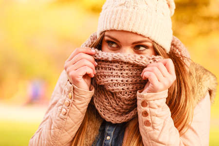 Clothing fashion concept. Woman with scarf and cap. Attractive lady wearing woolen clothes for autumnal season.の写真素材