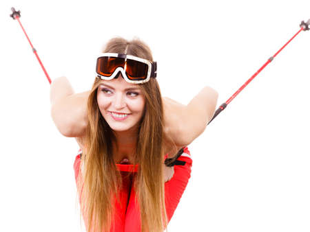 Movement body, sport concept. Young lady sliding down. Woman with long blonde hair with ski poles and goggle on her head.の写真素材