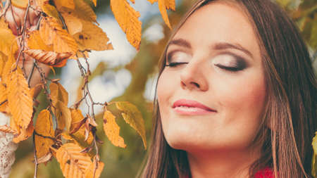 Fall lifestyle concept, harmony freedom. Attractive young woman fashion girl long hair relaxing walking in autumnal park, outdoorの写真素材