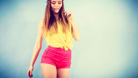 Healthy lifestyle. Happiness and joy. Young smiling fashionable girl in motion. Joyful sporty female teenager in jeans cap dancing.の写真素材