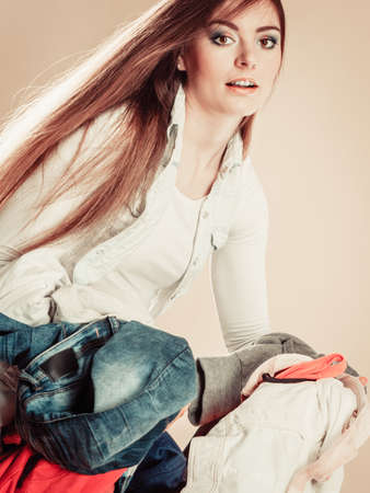 Daily routine in household laundry wash and ironing. Young girl hold pile of colorful clothes.