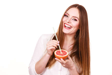 Woman attractive long hair girl colorful eyes makeup holding grapefruit citrus drinking juice from fruit. Healthy diet food. Summer vacation holidays concept. Copy space for textの写真素材