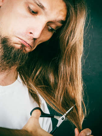 Trim and cut concept. Young handsome man cutting his hair. Change of look.  Barber and hairdresser.の写真素材