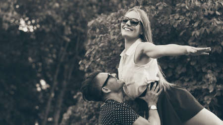 Love romance outdoor fun playing concept. Girl raised by her boyfriend. Young woman resting on arms of her man.の写真素材